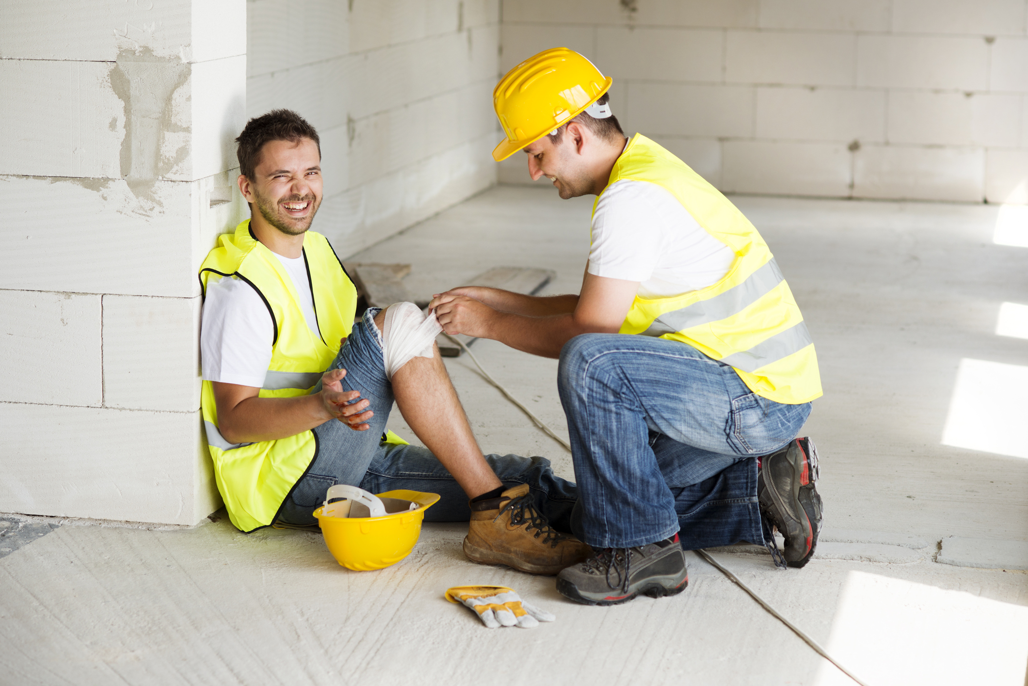 Man workplace physical injury with colleague helping to manage his knee